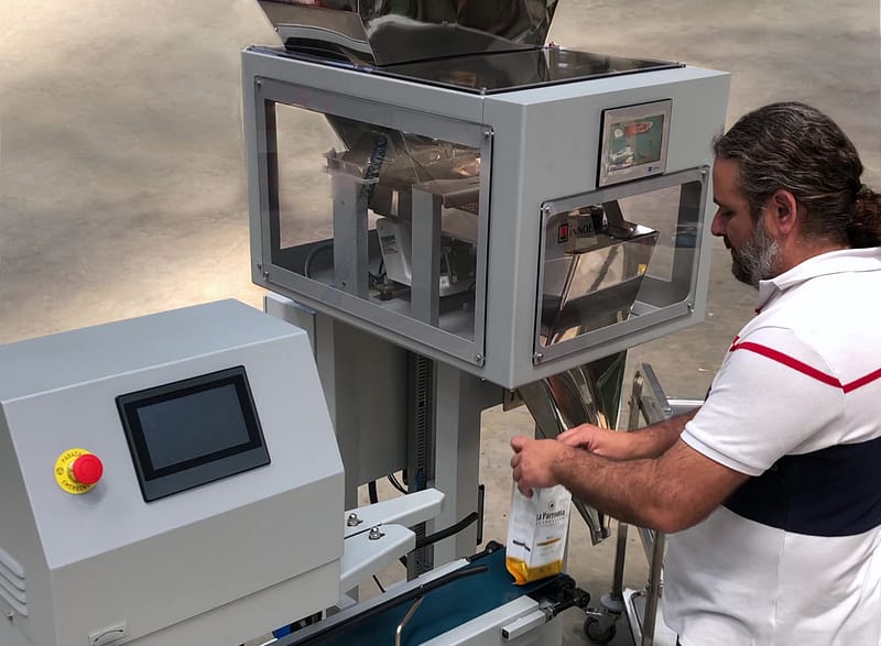 A man operating and filling bags with semiautomatic weigher model ESI-1
