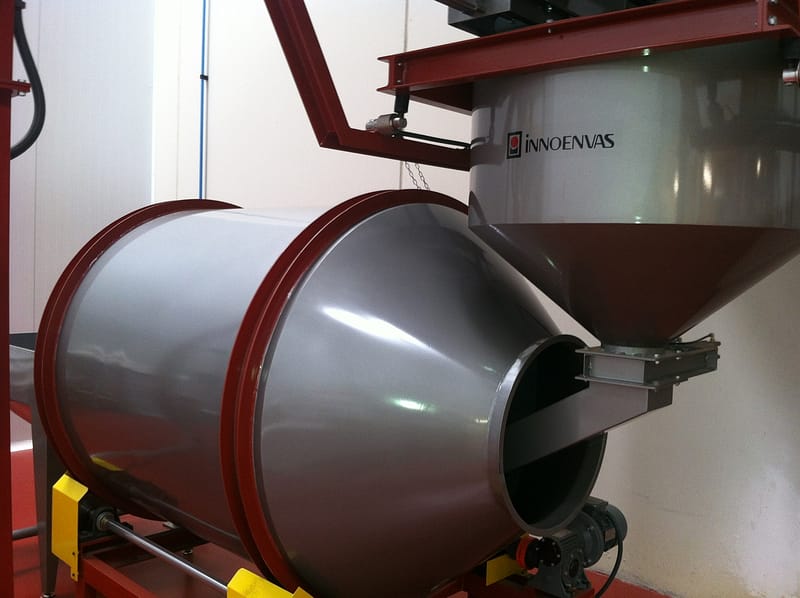 Rotary mixer connected to storage silo of roasted coffee beans as part of a coffee processing factory