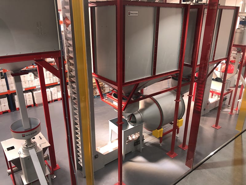 Coffee bean storage silos and rotary mixer and grinder as part of a production line in a coffee factory