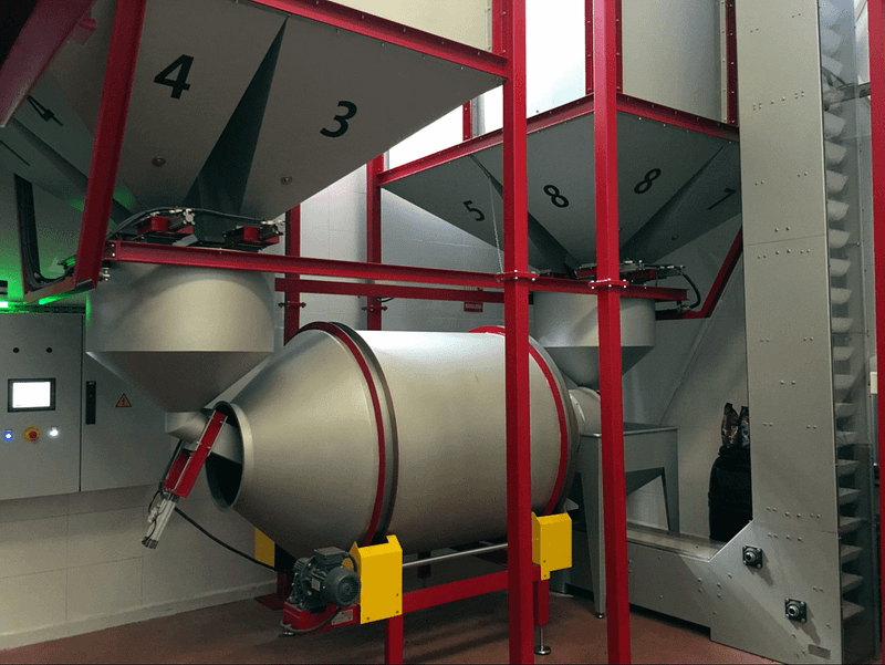 Rotary mixer under storage silos of roasted coffee beans as part of the coffee processing factory